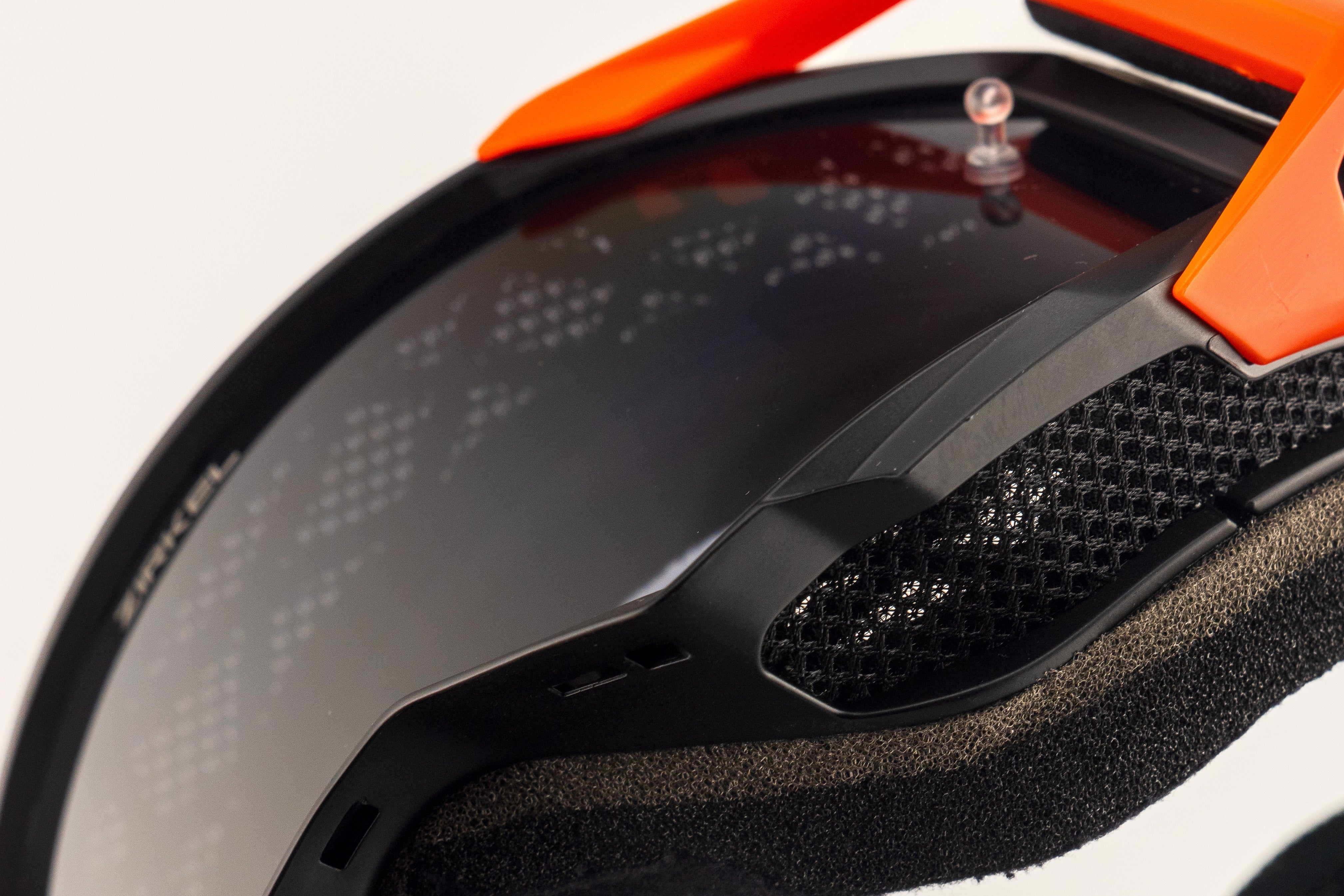 Close-up of a helmet with an orange and black design on a white background