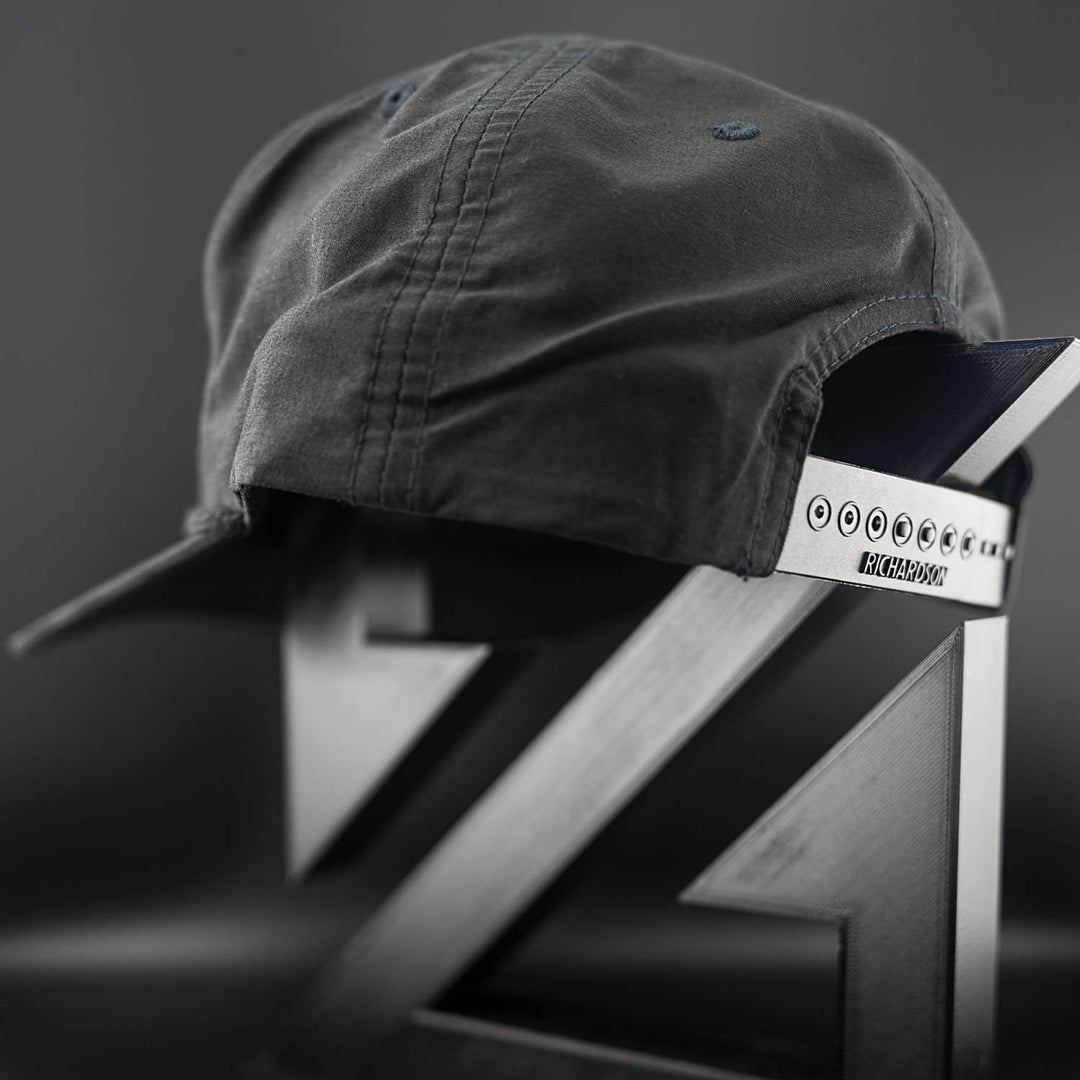 Black Zirkel Ridge Cap with a Richardson brand label on a metallic surface against a dark background