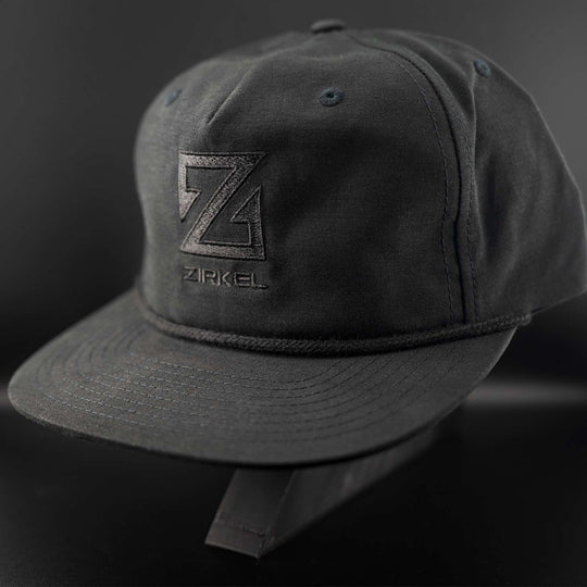 Black cap with a black Zirkel logo on a dark background
