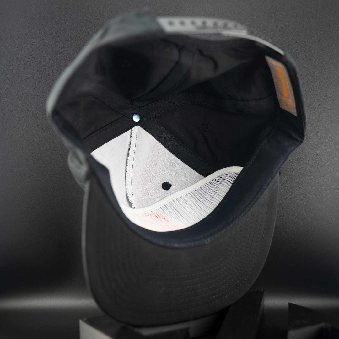 Black Zirkel Ridge Cap with white interior on a dark gray background